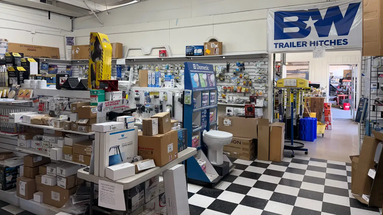 The stocked parts store inside High Desert RV Services, with a doorway through to the shop